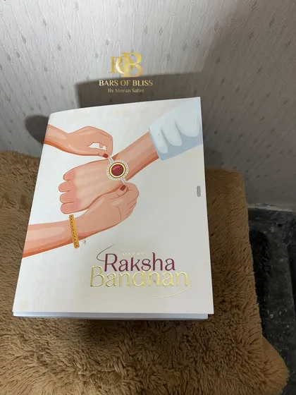 The beautifully illustrated cover of the Raksha Bandhan gift box, which adds a traditional touch to the modern treats inside.