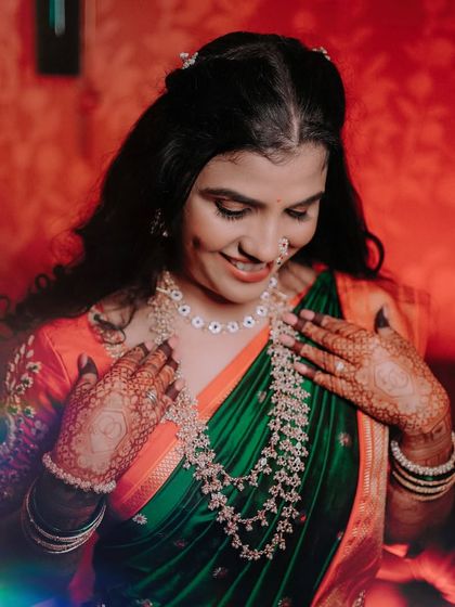 A lovely portrait of the bride in her green and orange saree. The soft, colorful light leak adds a dreamy and artistic touch to the photo, capturing her gentle smile. (Duplicate of 34)