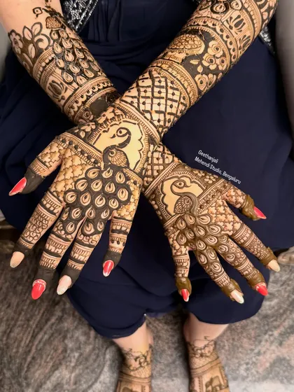 The peacock is a classic and beloved motif in Indian mehendi. Here, I've created a symmetrical design with bold peacocks on the back of the hands, complemented by intricate jaali (net) patterns on the arms.