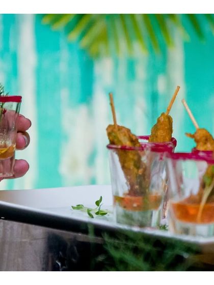 Chicken satay skewers served in shot glasses with a peanut dipping sauce. The vibrant colours and clean presentation make this a visually appealing and delicious appetizer.