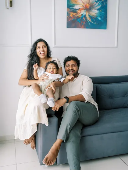 A happy family sitting on the couch at home. The relaxed setting allows for natural smiles and comfortable interactions.