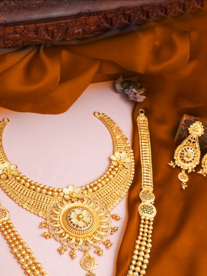 This complete yellow gold bridal set features a choker, long necklace, and matching bracelets. The fine, detailed patterns and floral motifs make it a timeless and elegant choice.