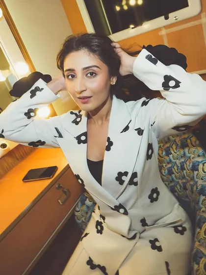 A candid moment in the vanity. Dhvani Bhanushali getting ready for a show in a fun, floral-printed pantsuit, giving a glimpse into the pre-show excitement.