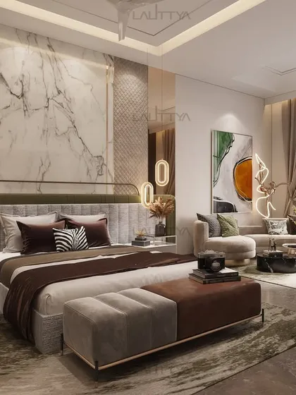 Another view of the sophisticated bedroom, highlighting the comfortable lounge area by the window. The mix of a soft sofa and a green armchair provides a perfect spot for relaxation.