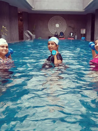 Using aquatic dumbbells, these members are strengthening their upper bodies. The water provides constant resistance, making every movement an effective part of this toning exercise.