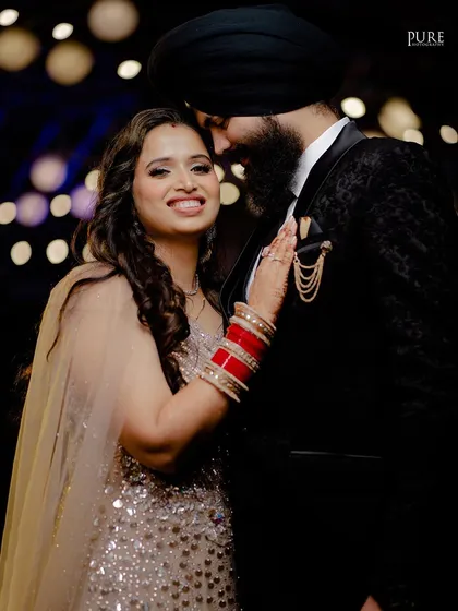 A joyful reception portrait. The bride's bright smile and the couple's happy embrace capture the celebratory spirit of the night.