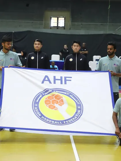 Officials hold the Asian Handball Federation (AHF) flag at the start of the tournament. We work closely with international sports federations to execute events flawlessly.