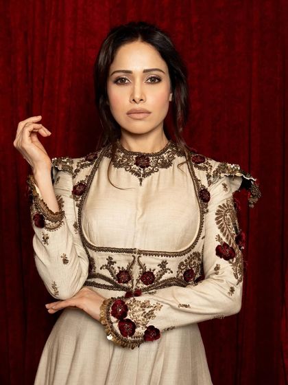 A close-up portrait focusing on Nushrratt's expressive hands and direct gaze, adding a narrative quality to the image.