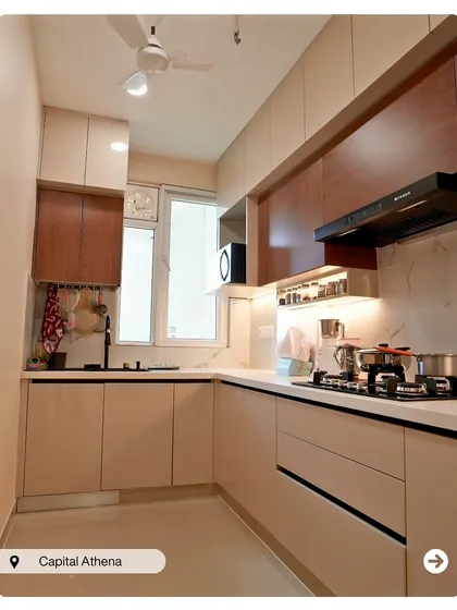 A compact and efficient L-shaped kitchen in neutral tones. The combination of beige and wood-finish cabinets creates a warm and timeless look.
