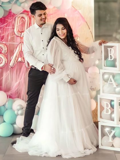 This white flare gown is perfect for a baby shower or an angelic maternity shoot. It features a sequined bodice and dramatic long balloon sleeves for a touch of whimsy.