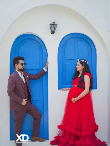 A romantic shot of a couple looking at each other, framed by the vibrant blue doors of a studio set.