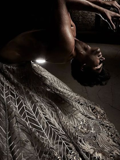 A dramatic pose from the Shantanu & Nikhil Summer 2022 campaign. The choreography aimed to create sculptural shapes with the body and fabric, resulting in visually arresting images.