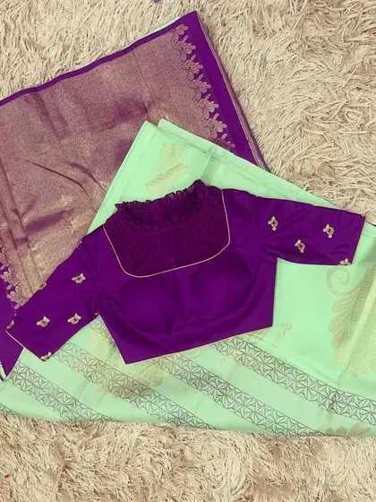 A bay green silk saree with a violet border, paired with a simple but elegant violet embroidered blouse.