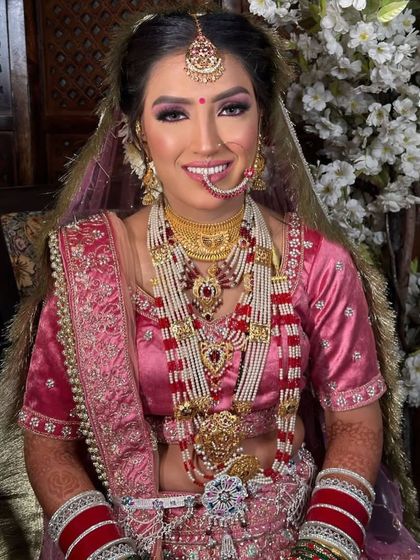 A close-up of Anjali's bridal makeup. You can see the detailed eye work and how the jewelry is perfectly placed to enhance her features. Her smile says it all.