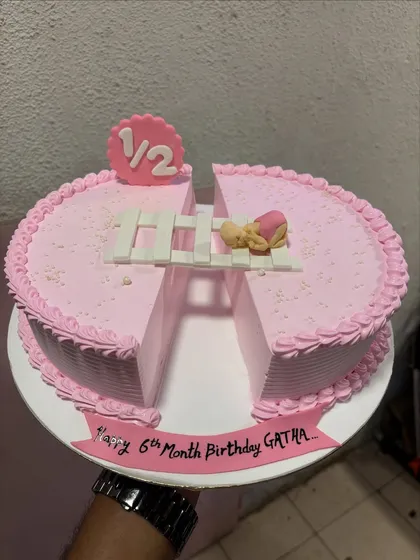 A creative half-birthday cake, designed as two semi-circles to represent the "1/2" milestone. It's a lovely way to celebrate six months of joy.