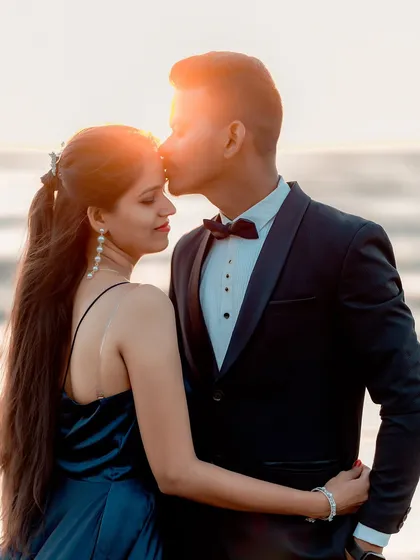 A romantic pre-wedding portrait on the beach as the sun sets. The warm light creates a beautiful, intimate atmosphere for couple photography.