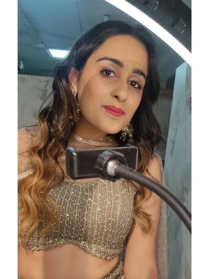 A behind-the-scenes selfie taken during a makeup session. The ring light ensures the makeup is applied perfectly for any lighting condition.