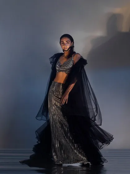 A full view of the wet-look hair and makeup, paired with a shimmering, sea-inspired outfit. The entire look is cohesive, telling a story of fluidity and light.