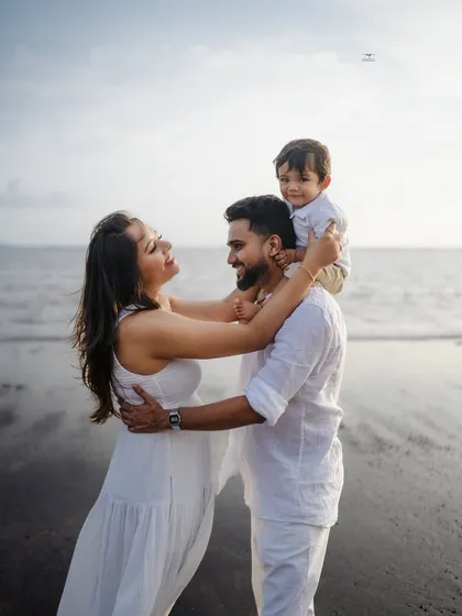 There's nothing like the joy of a growing family. This candid moment on the beach, with a happy toddler on his dad's shoulders, perfectly captures the love and excitement before a new arrival.