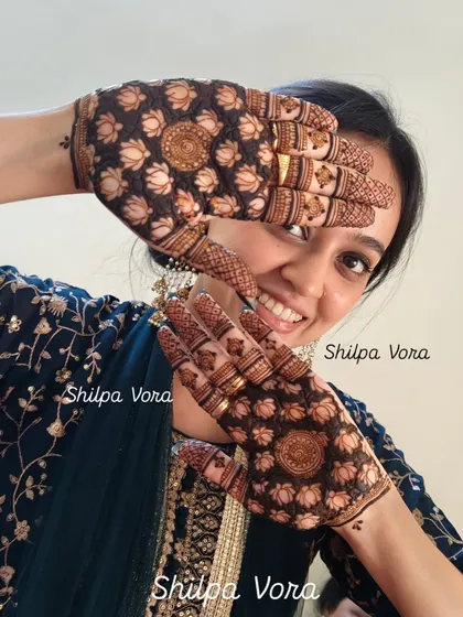 A happy bride-to-be showing off her stunning lotus mehndi. The dense pattern on the palms is one of my signature styles, combining bold floral elements with fine, delicate lines for a balanced and beautiful finish.