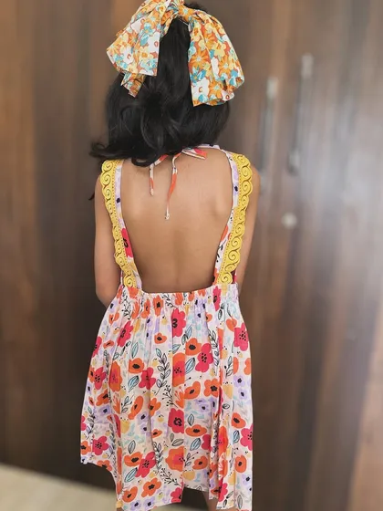 Another look at our whimsical floral backless frock. The details on the back make it so special, and the soft cotton ensures it's comfortable enough for all-day wear.