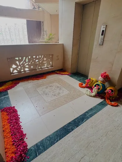 The lift lobby area decorated with a beautiful flower petal rangoli and traditional decorated pots (matkas).