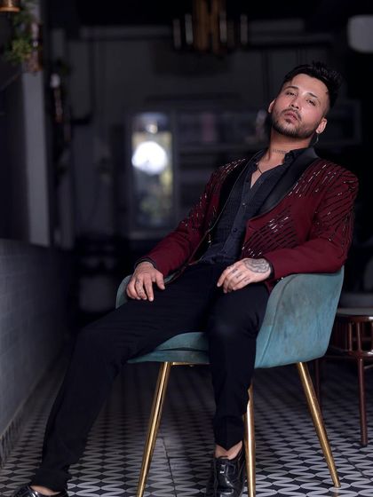 This client relaxes in style, wearing our maroon sequin tuxedo. It's a versatile piece that looks great whether you're standing or sitting.