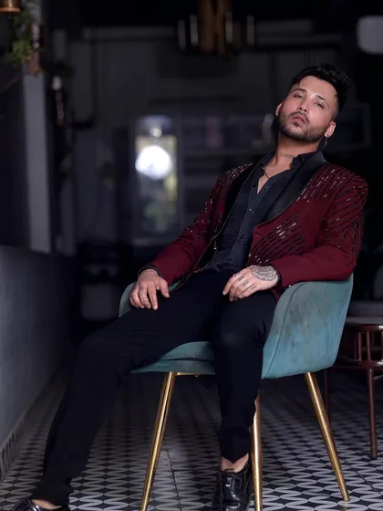 This client relaxes in style, wearing our maroon sequin tuxedo. It's a versatile piece that looks great whether you're standing or sitting.