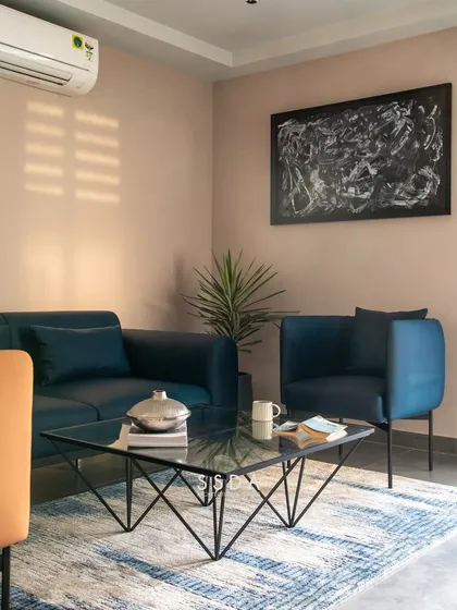 The waiting area in our studio, with a comfortable blue sofa and armchairs. The space is designed to be welcoming and reflective of our modern, layered style.