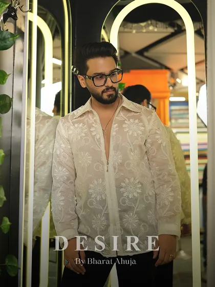 A portrait in the sheer floral shirt, highlighting the intricate embroidery and the modern, sophisticated vibe.