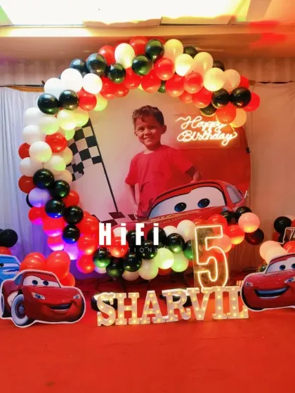 A full view of the Disney Cars 5th birthday party setup on a stage.