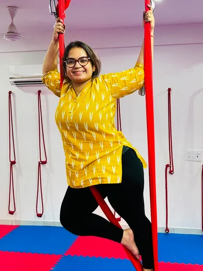 Confidence grows with every class. This student smiles as she finds her balance and strength in a suspended pose, ready to take on new challenges.
