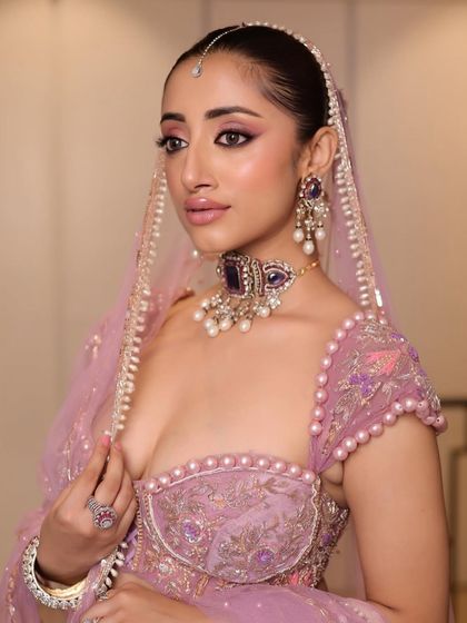 A dazzling look perfect for a cocktail party or reception. This bride’s makeup features dramatic, winged eyes and a glossy lip, paired with a sleek hairstyle for a high-fashion, glamorous feel.