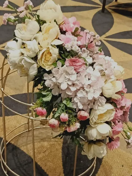 A detail shot of a floral arrangement in a golden birdcage, a small but beautiful element that adds to the overall romantic theme of the engagement party.