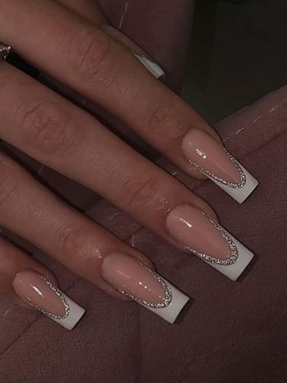 A glamorous update to the French manicure. This design features the classic white tip on a square nail, outlined with a fine line of silver glitter.