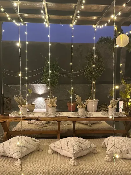 A closer look at the boho-chic table setup, featuring dried floral arrangements and textured cushions for a cozy and stylish feel.