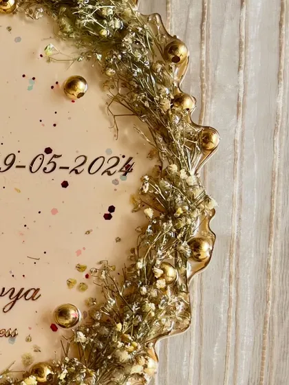 A close-up of the gypsophila and golden beads used in a custom flower photo frame. These small details add so much texture and elegance to the final piece.