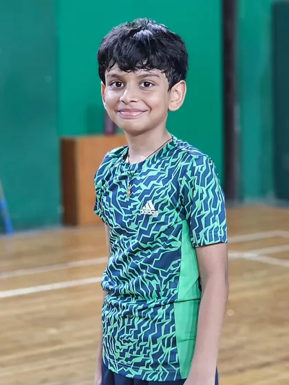 A young player smiles for the camera, happy to be on the court and improving his game.