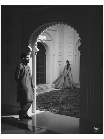 We love playing with light and shadow to create artistic and timeless portraits. This black and white shot, framed by a majestic archway in Udaipur, highlights our creative approach to composition, turning a simple moment into a piece of art.