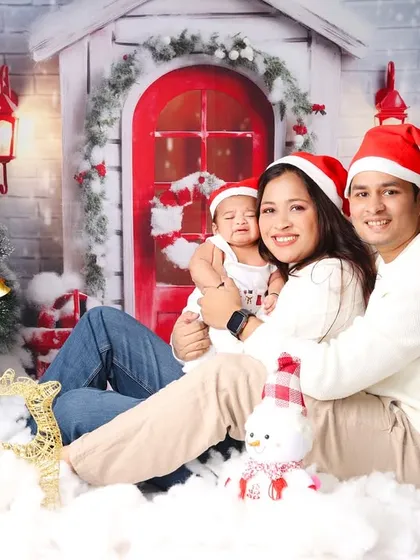 The perfect family Christmas card photo. The whole family, dressed in cozy sweaters and Santa hats, shares a happy moment in our festive studio setup.