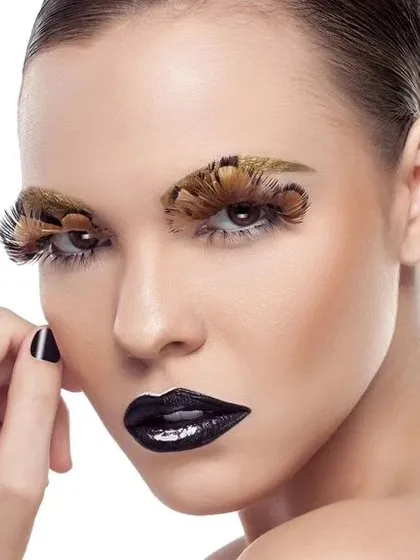 A full-face view of the dramatic beauty look with feather eyelashes. The clean lighting and white background make this a powerful image for a makeup or beauty portfolio.