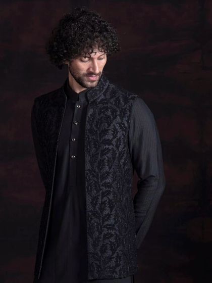 A classic black kurta paired with an intricately embroidered waistcoat. This is a versatile look that can be dressed up or down for any formal occasion.