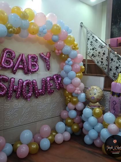 Another angle of the pastel-colored baby shower arch, showing a cute lion-themed balloon column next to it.