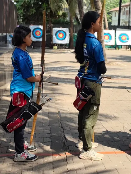 Two young girls waiting on the shooting line. They learn from and support each other.