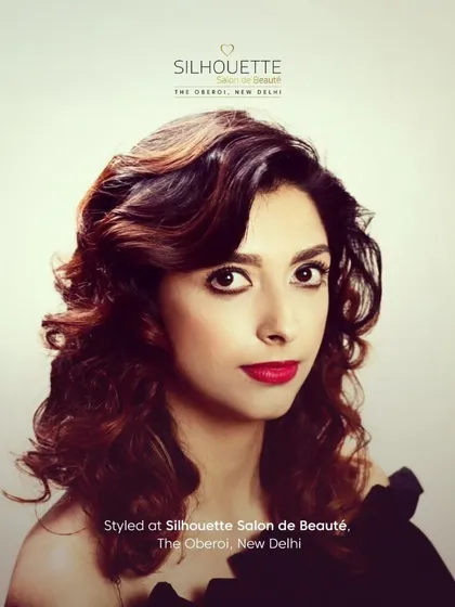 Another stunning look for Aishwarya Jha, featuring voluminous curls and a bold red lip. We create versatile styles for any occasion.