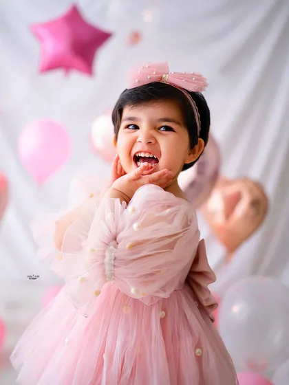 That pure, uncontainable joy of turning two! Milestone sessions are all about celebrating these big little moments. Her infectious laugh and excitement surrounded by birthday balloons make this a perfect memory of her special day.