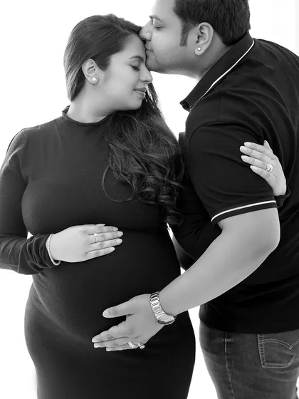 A tender moment captured in a timeless black and white style. This pose is perfect for showcasing the couple's bond during their pregnancy journey.