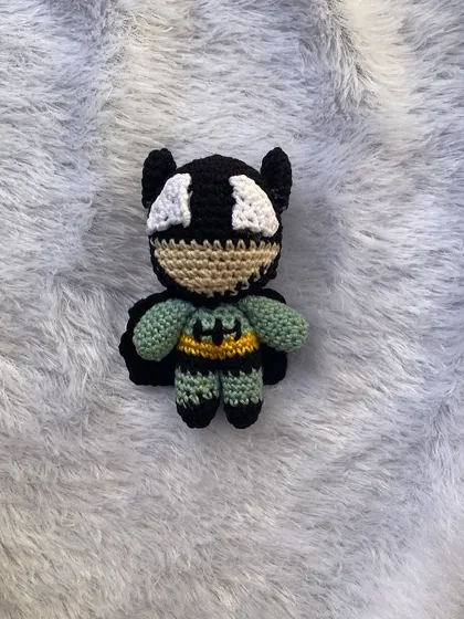 A mini Batman amigurumi, complete with his cape and symbol. This little guy is ready to protect your desk or join a superhero-themed bouquet.