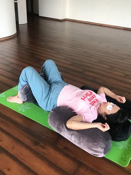 Comfort is key to a nourishing practice. Here, a mother-to-be finds deep rest supported by bolsters and an eye pillow. I believe in using props to help you release tension, find proper alignment, and surrender completely.
