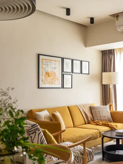 This living room from 'Penny's Home' showcases our approach to Japanese-inspired Wabi-Sabi design. The vibrant mustard sofa acts as a centerpiece, balanced by the natural pine wood of the accent chair and simple, functional furniture. It’s a space that proves beautiful design can be warm, accessible, and full of personality.